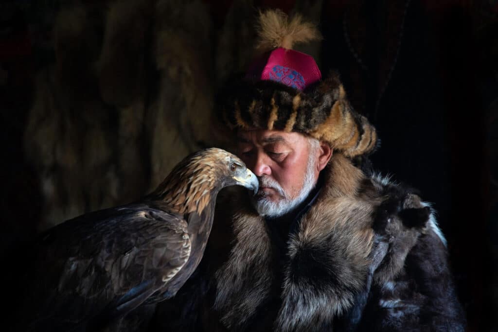 Een traditionele Kazachse adelaarsjager met zijn steenarend in Mongolië